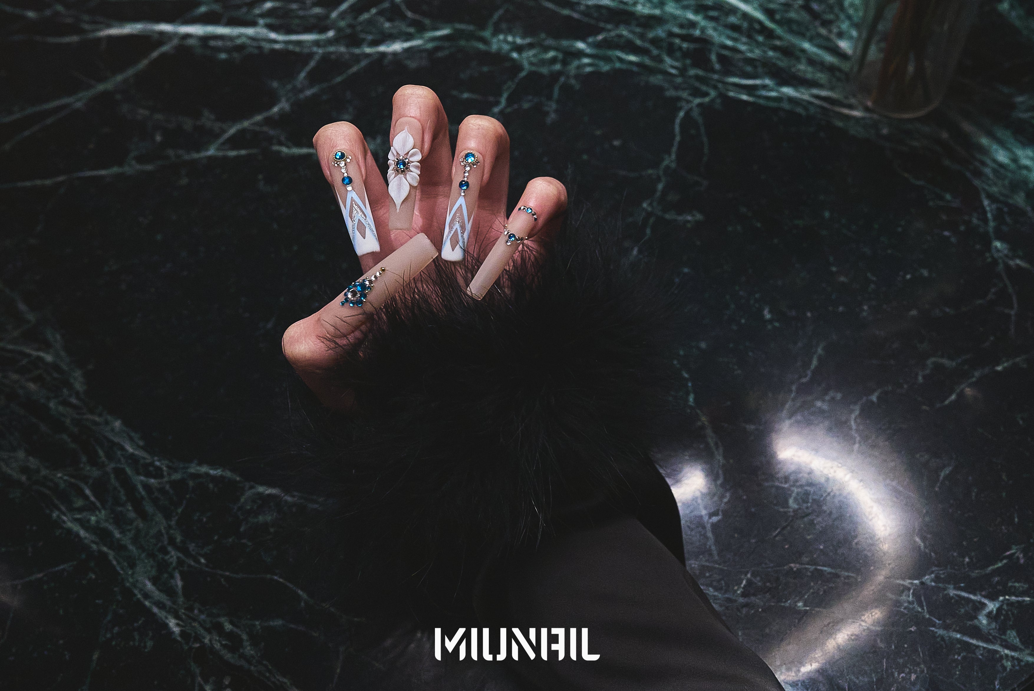 Hand with ‘Frost Waltz’ long square press-on nails posed over a dark marble surface, featuring MiuNail branding and dramatic lighting.