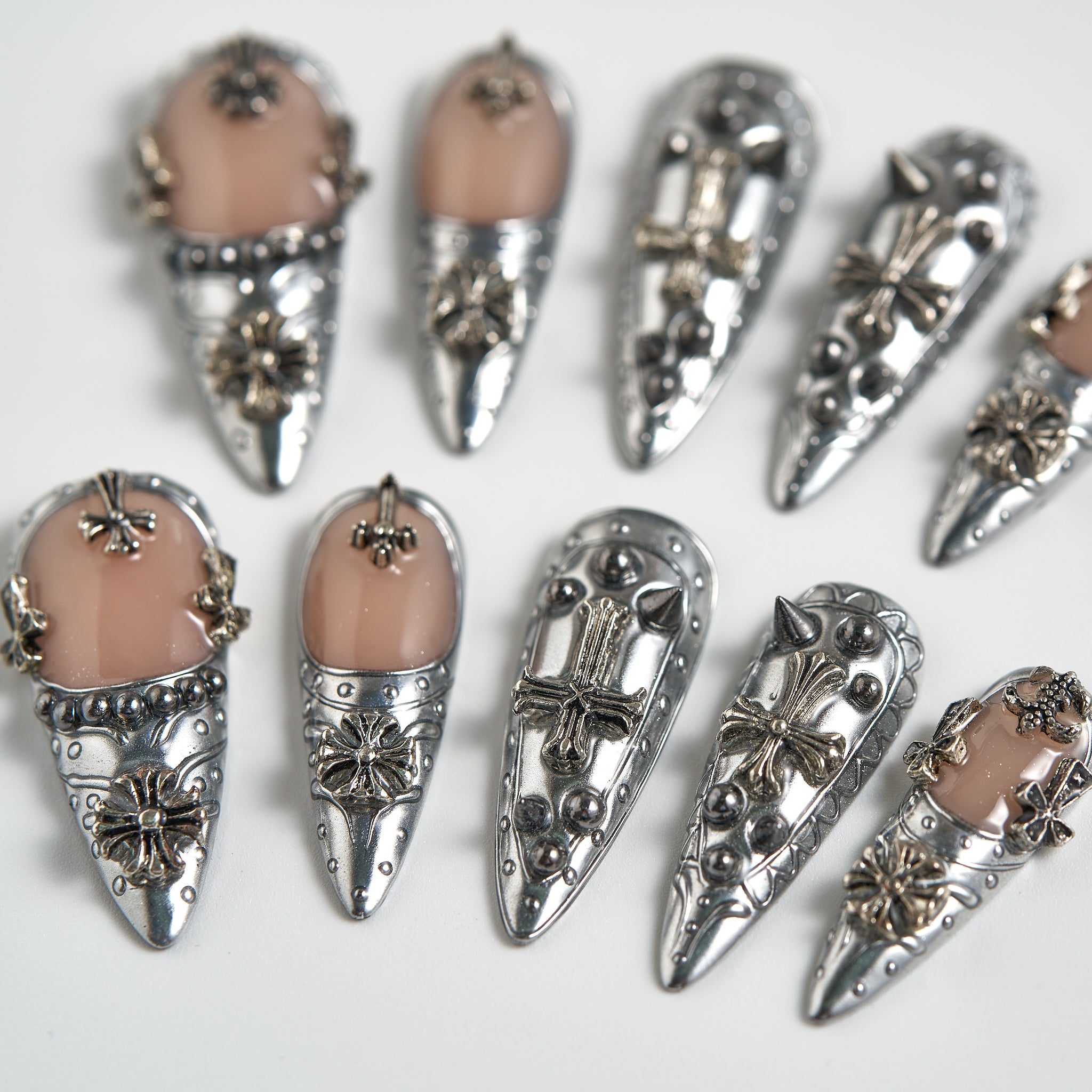 Chrome Reign stiletto press-on nails in metallic chrome silver, close-up of salon-quality reusable nails with 3D embellishments on white background