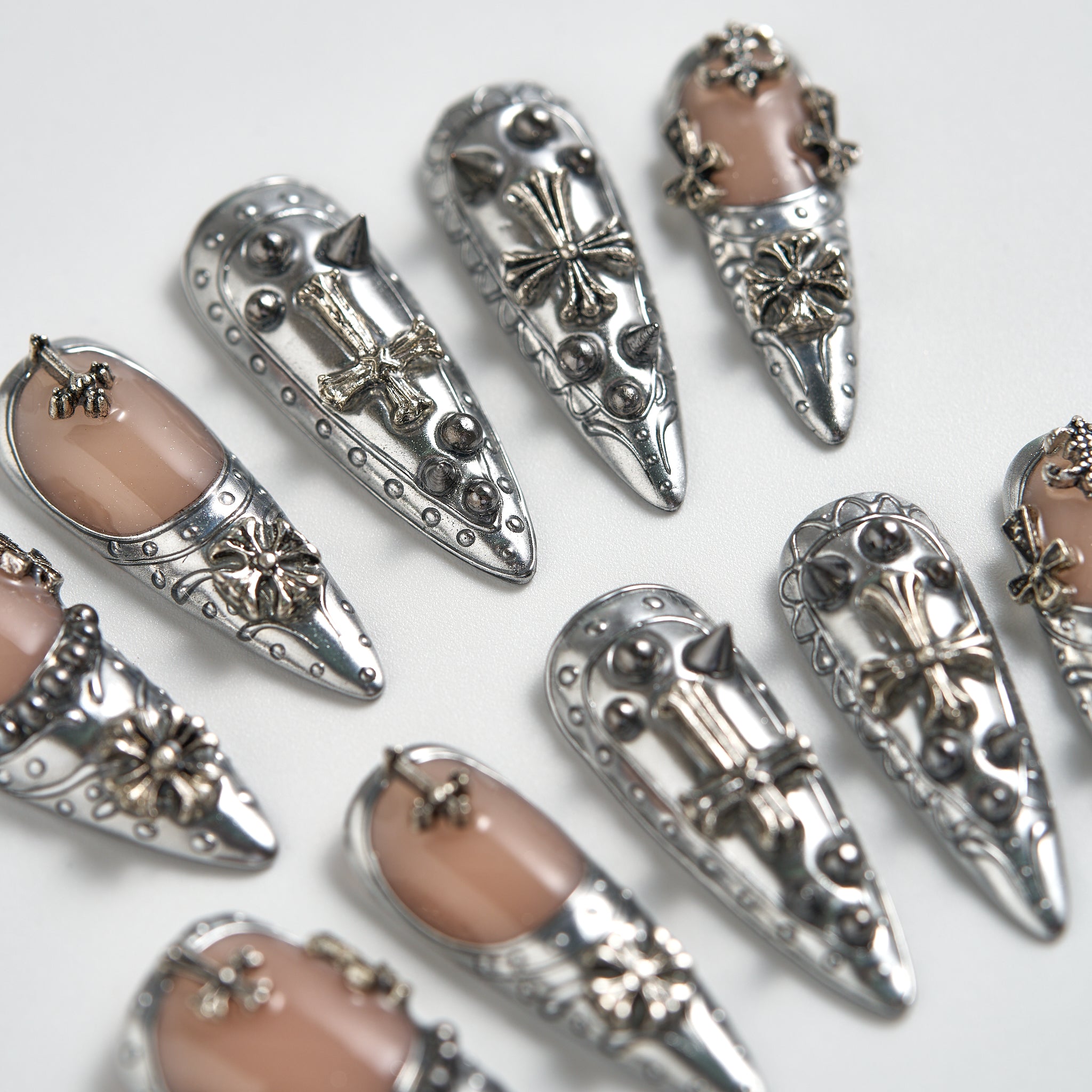 Chrome Reign stiletto press-on nails in metallic chrome silver, close-up showing 3D art accents, reusable salon-quality nails on white background