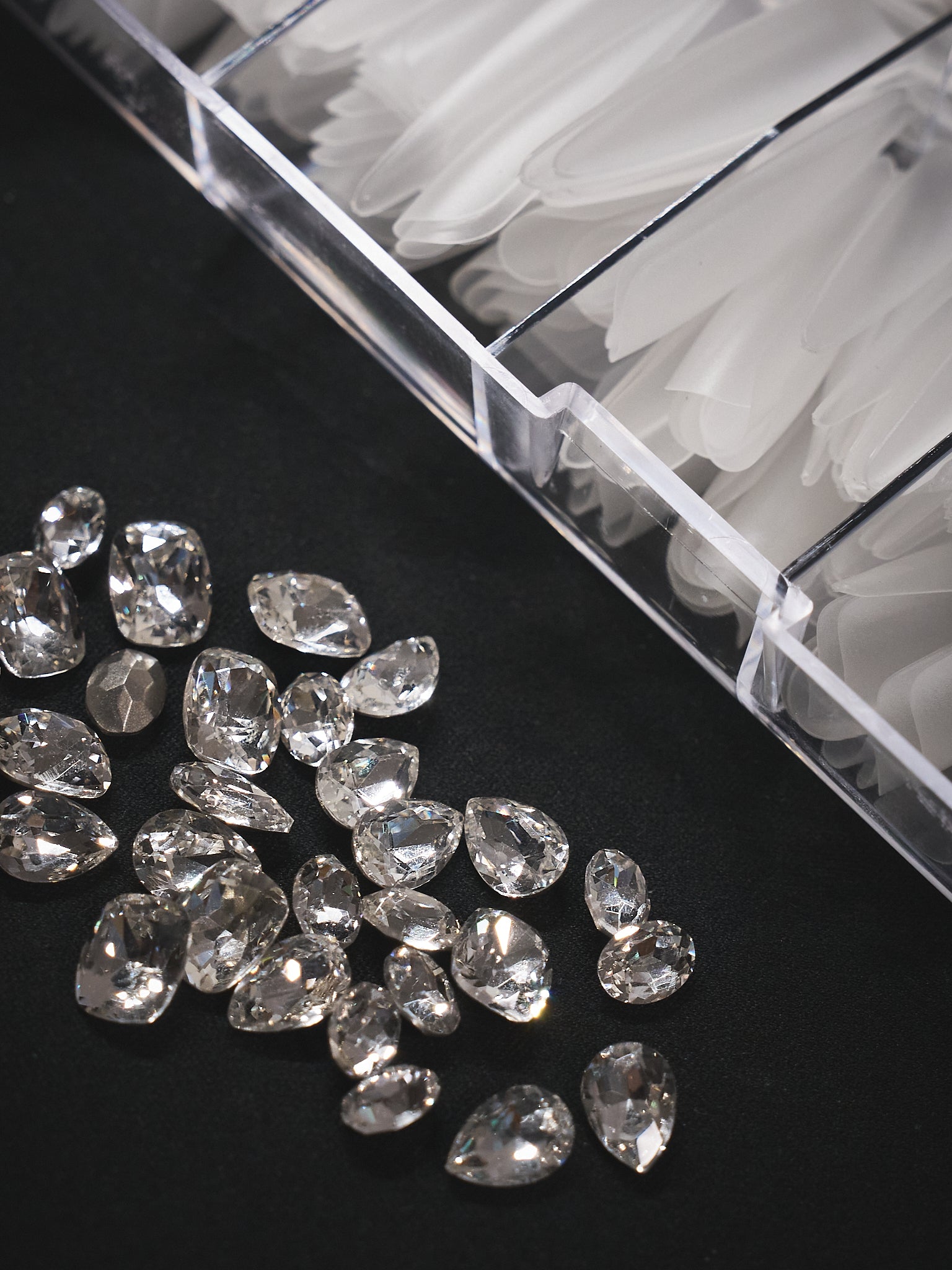 Premium MiuNail press-on nail materials: clear acrylic tips and assorted high-quality rhinestones, showcasing salon-grade quality and a commitment to comfort, safety, and lasting brilliance.