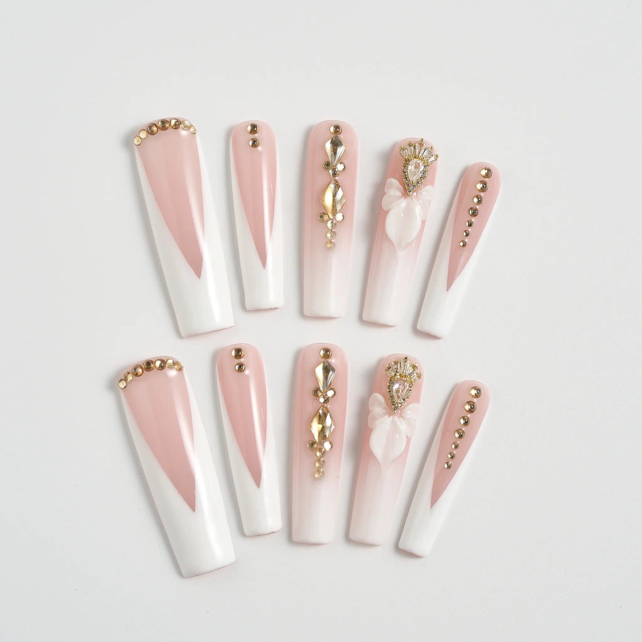Set of decorative false nails with pink and white design on a light gray background