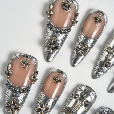 Decorative nail art with silver and gold accents on a white background