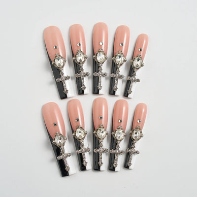 Set of decorative false nails with crosses and crystals on a light gray background