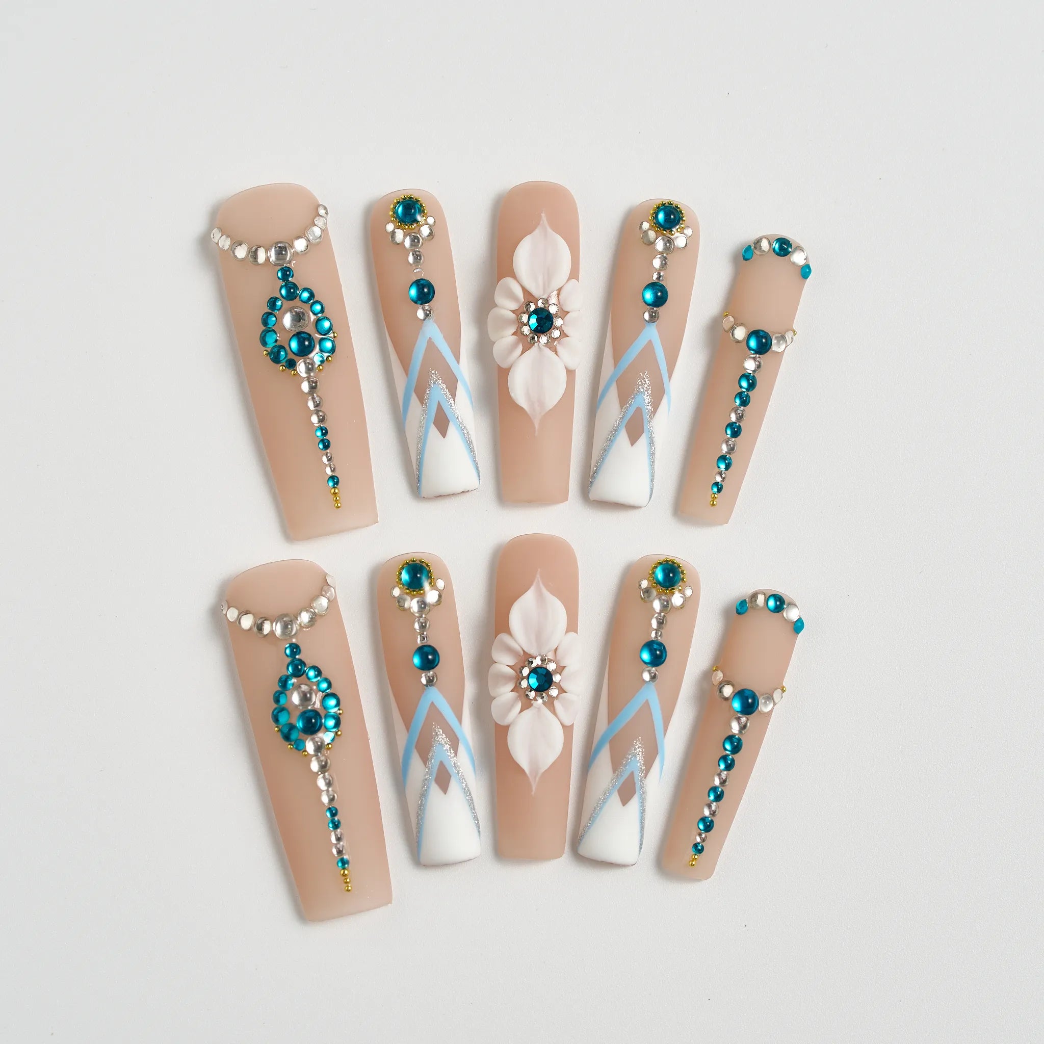 Decorative false nails with beads and flowers on a light background