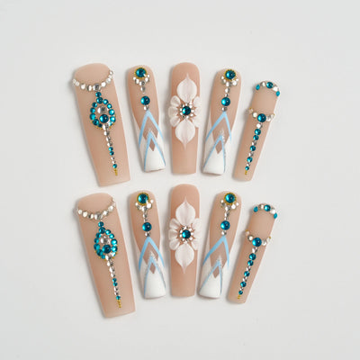 Decorative false nails with beads and flowers on a light background