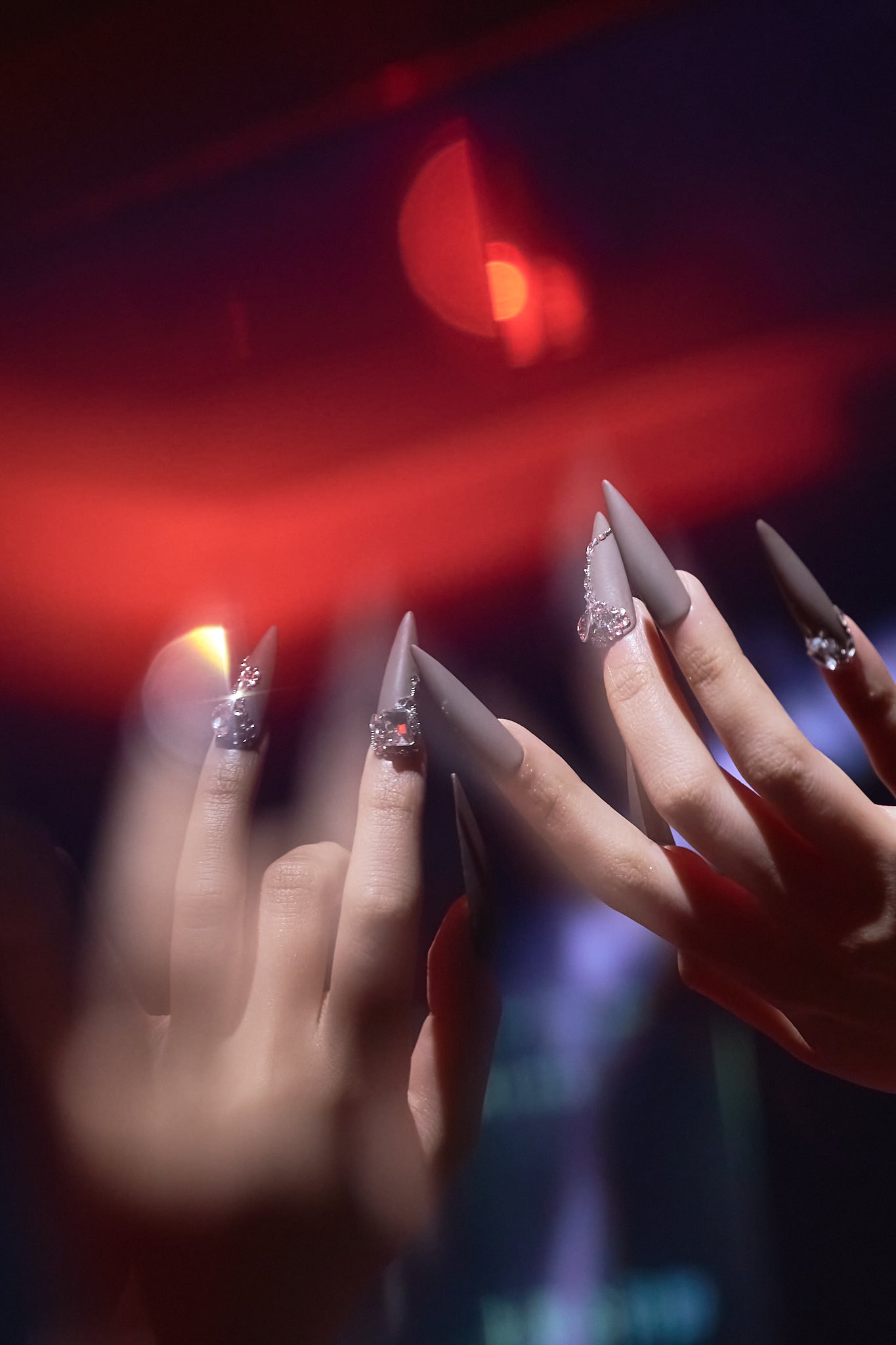 Close-up of hands wearing MiuNail “Desert Halo” matte press-on nails with crystal rhinestone accents, featured in the testimonials banner background.
