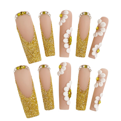 Long square ‘Golden Bloom’ press-on nails with gold glitter, 3D white daisies, and beige base on a white background.