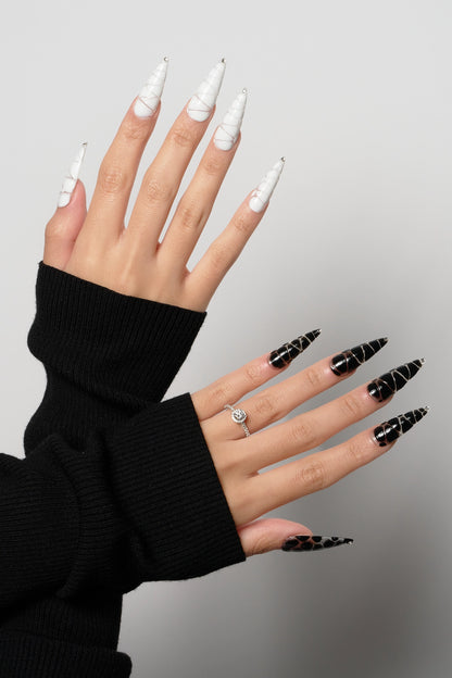 MiuNail Venom Twist press-on nail set featuring sculptural black and white spiral shells with metallic chrome tips, displayed on a white background.