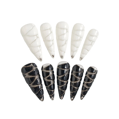 MiuNail Venom Twist press-on nail set featuring sculptural black and white spiral shells with metallic chrome tips, displayed on a white background.