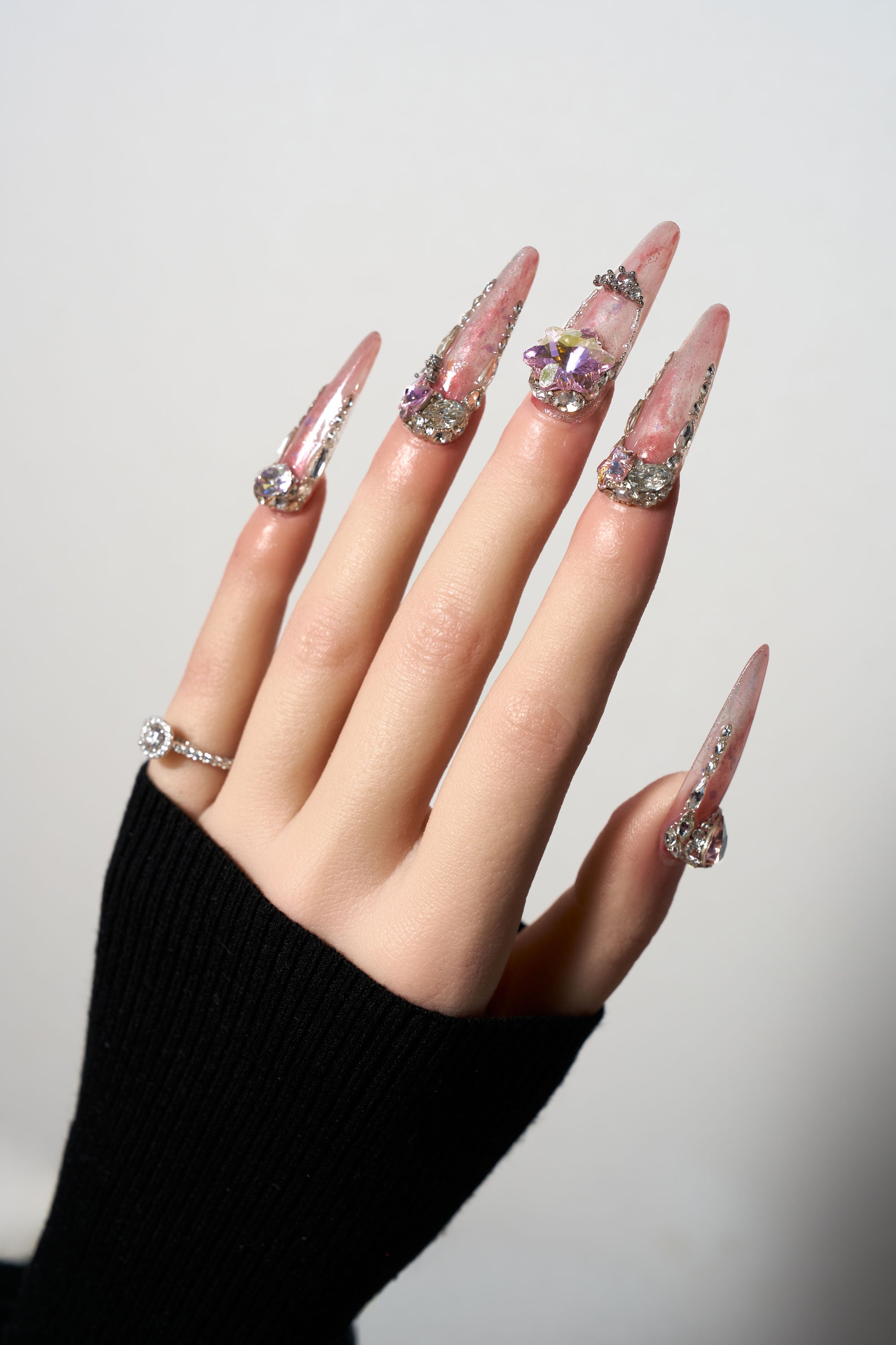 Princess Relic reusable extra-long stiletto press-on nails featuring a dreamy iridescent pink marble base, heavily adorned with luxury silver crystal clusters, a large 3D star-shaped gemstone, and intricate rhinestone crown accents.