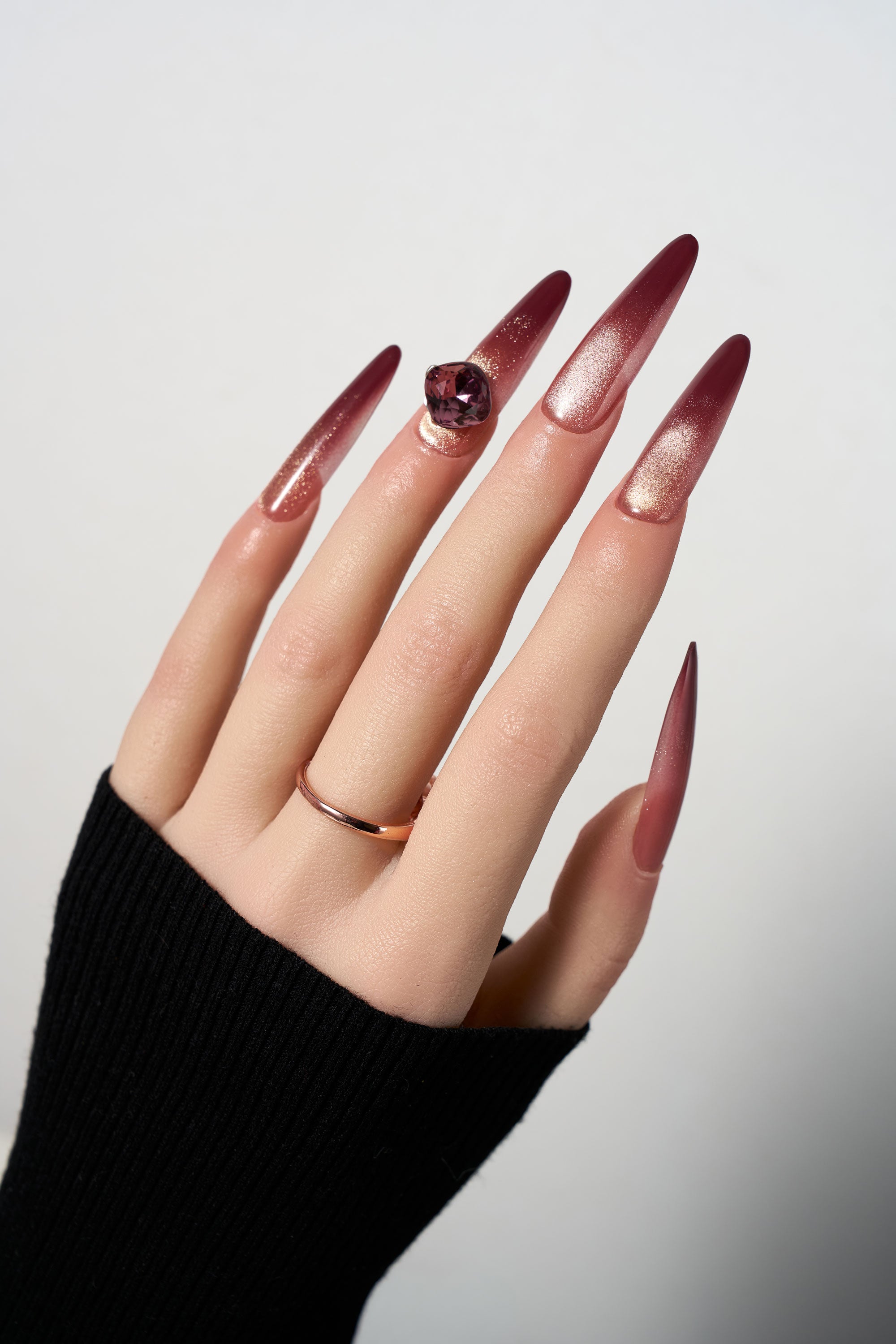 Rosé Garnet reusable extra-long stiletto press-on nails featuring a deep burgundy to rose gold ombre cat-eye effect, highlighted by a massive centerpiece purple square-cut gemstone.