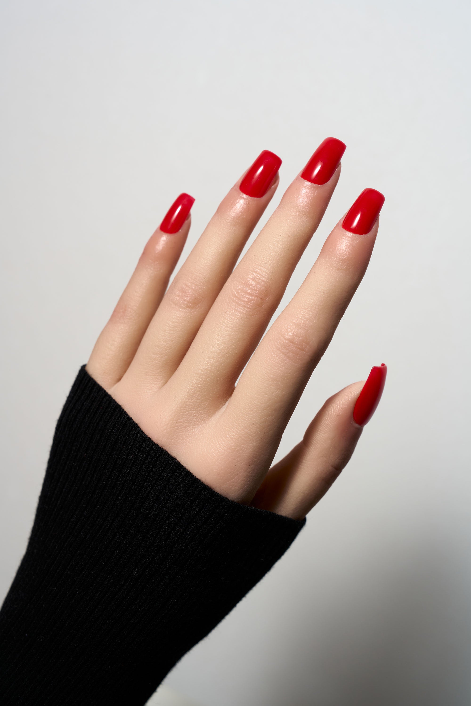 Ruby Poise press-on nails in a classic vibrant red with a high-gloss finish, featured in a sophisticated medium square shape.