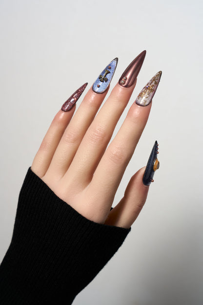 Violet Eclipse stiletto reusable press-on nails with a purple cat-eye finish, featuring gothic 3D metallic charms, celestial motifs, and copper-toned accents for a mystical look.
